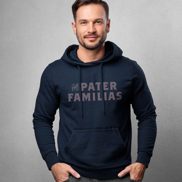 Man wearing a navy hoodie with 'The Pater Familias' text on a gray background