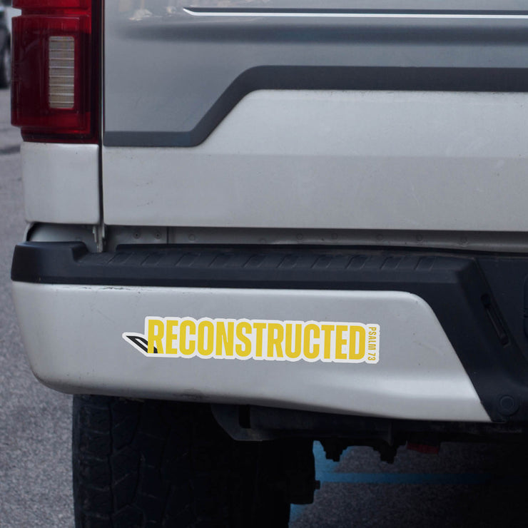 Vinyl decal with yellow RECONSTRUCTED text and Psalm 73 reference on bumper of silver truck
